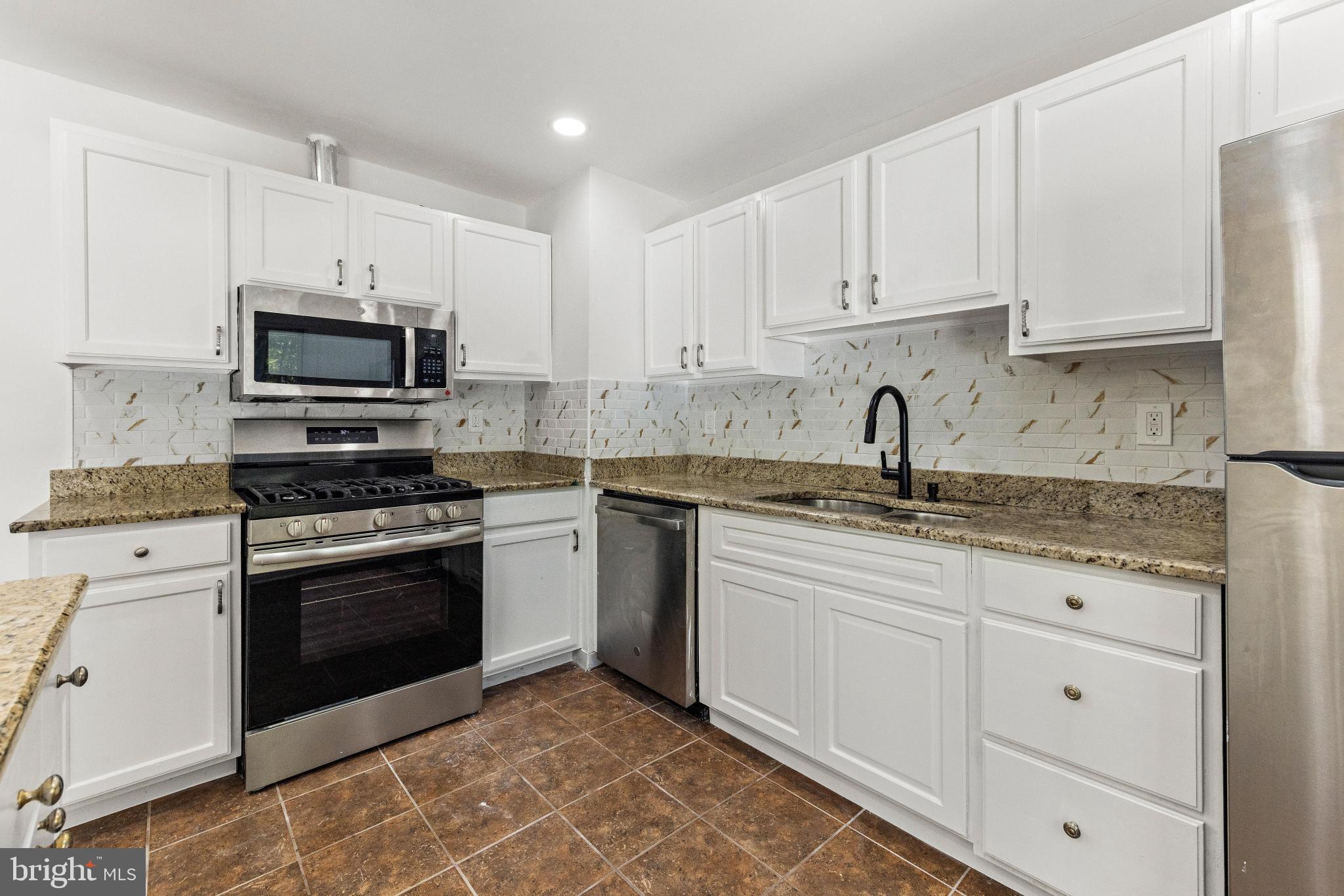 716 6th Road Newtonville, NJ 08346 - Photo 15 of 43 a kitchen with granite countertop white cabinets and stainless steel appliances