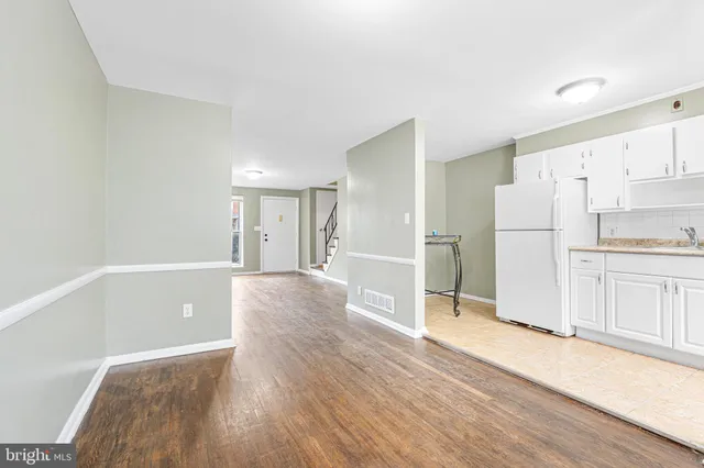 a view of a kitchen with wooden floor and electronic appliances