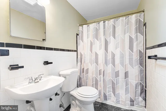 a bathroom with a sink toilet and mirror