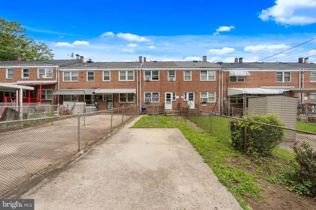 front view of a residential apartment building with a yard