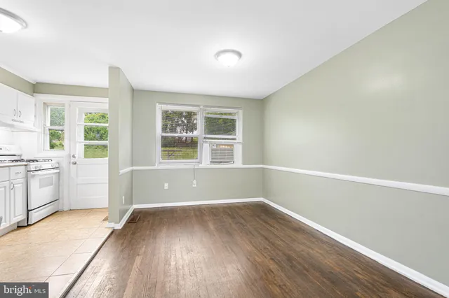 a view of empty room with a window and wooden floor