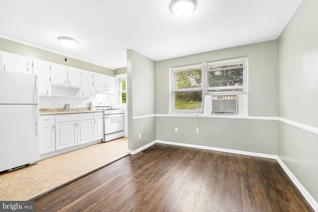 a kitchen with wooden floors and white appliances