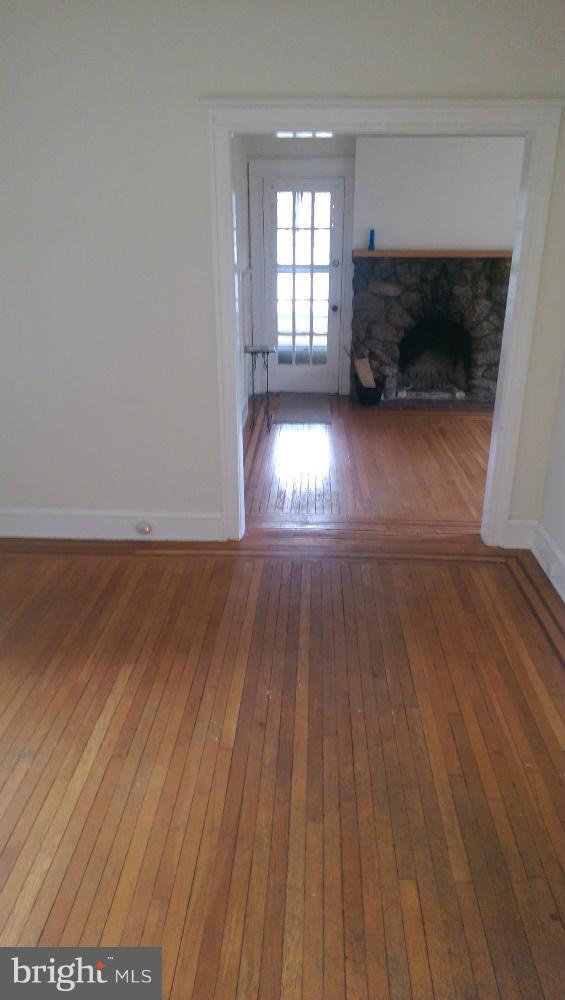 6000 Falls Road Baltimore, MD 21209 - Photo 8 of 13 a view of empty room with wooden floor and fireplace