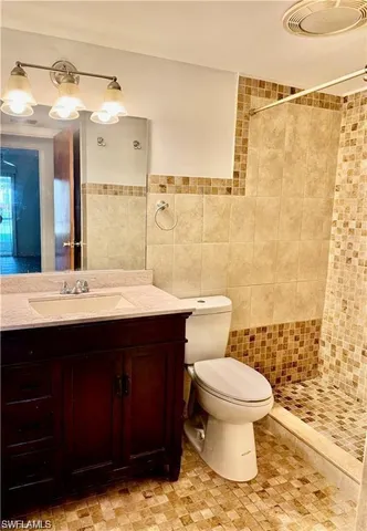 a bathroom with a sink vanity mirror and toilet