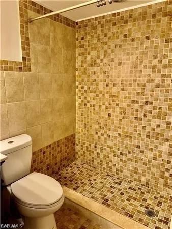 a bathroom with a toilet and a shower