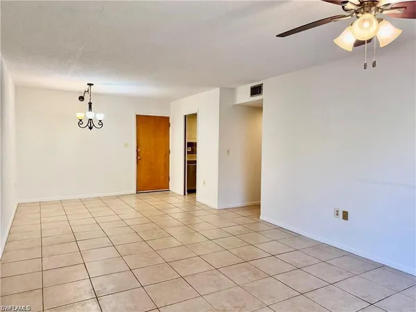 a view of a livingroom with a chandelier fan and windows