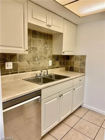 a kitchen with stainless steel appliances granite countertop a sink and dishwasher with white cabinets