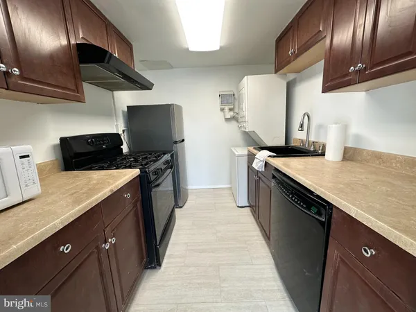 a kitchen with stainless steel appliances granite countertop a sink a stove and a wooden floors
