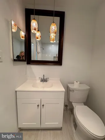 a bathroom with a toilet sink vanity and mirror