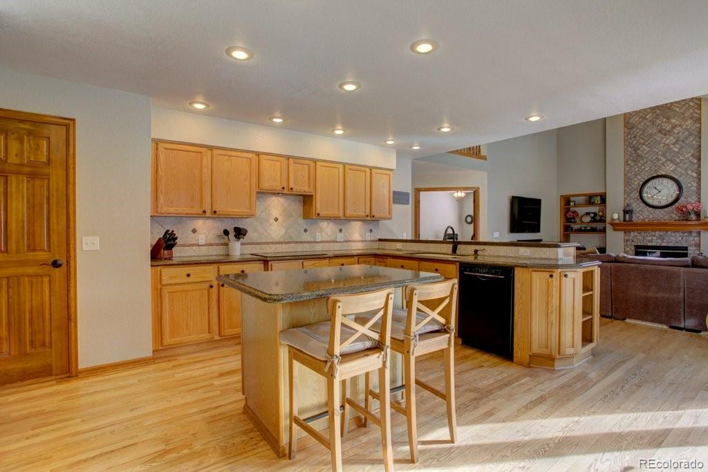 2364 Stratford Court Highlands Ranch, CO 80126 - Photo 12 of 35 a kitchen with stainless steel appliances kitchen island granite countertop a stove a sink a refrigerator and cabinets