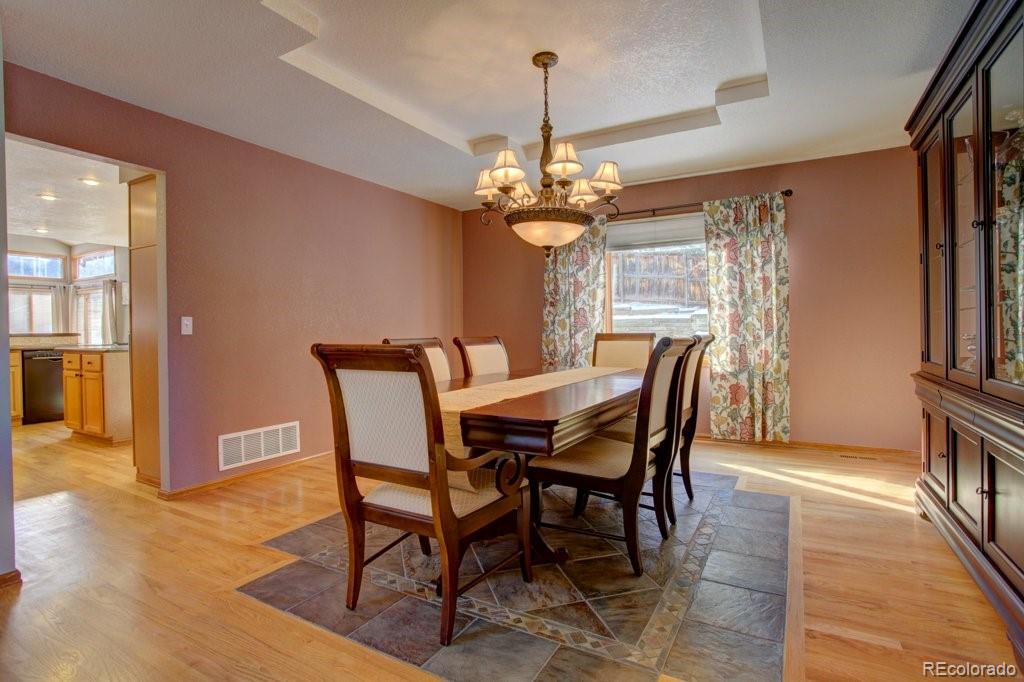 2364 Stratford Court Highlands Ranch, CO 80126 - Photo 13 of 35 a dining room with furniture a chandelier and wooden floor