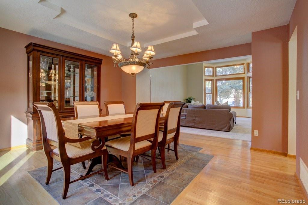 2364 Stratford Court Highlands Ranch, CO 80126 - Photo 14 of 35 a view of a dining room with furniture a chandelier and wooden floor