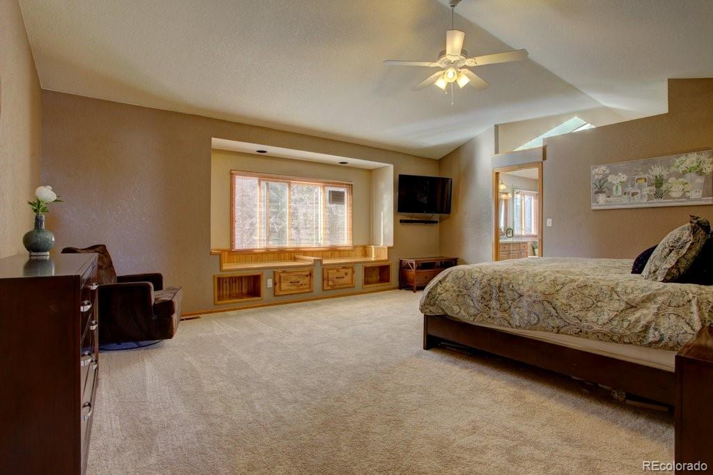 2364 Stratford Court Highlands Ranch, CO 80126 - Photo 20 of 35 a spacious bedroom with a bed and a chandelier