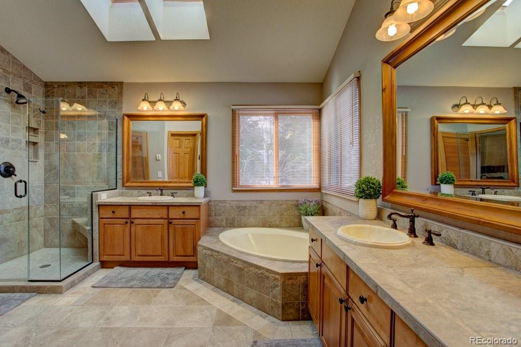 2364 Stratford Court Highlands Ranch, CO 80126 - Photo 24 of 35 a bathroom with a granite countertop sink mirror and a bathtub