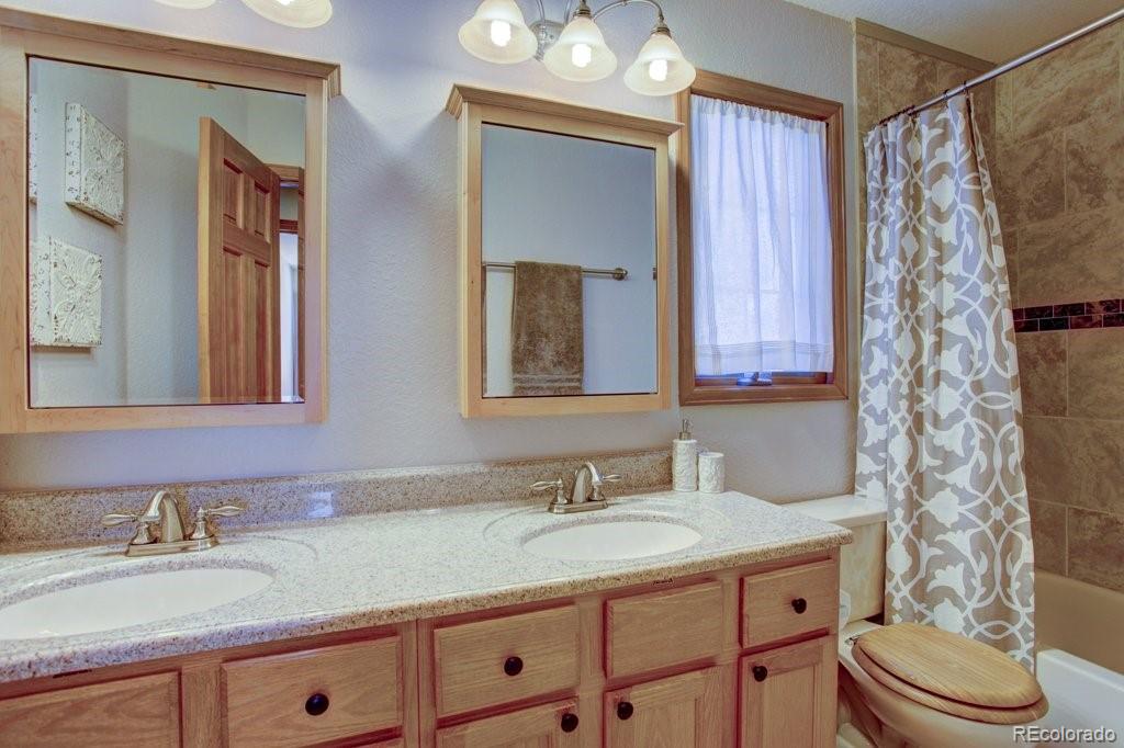 2364 Stratford Court Highlands Ranch, CO 80126 - Photo 27 of 35 a bathroom with a granite countertop sink toilet and mirror