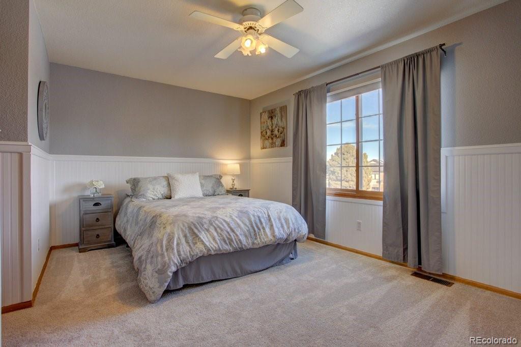 2364 Stratford Court Highlands Ranch, CO 80126 - Photo 28 of 35 a spacious bedroom with a bed and a chandelier