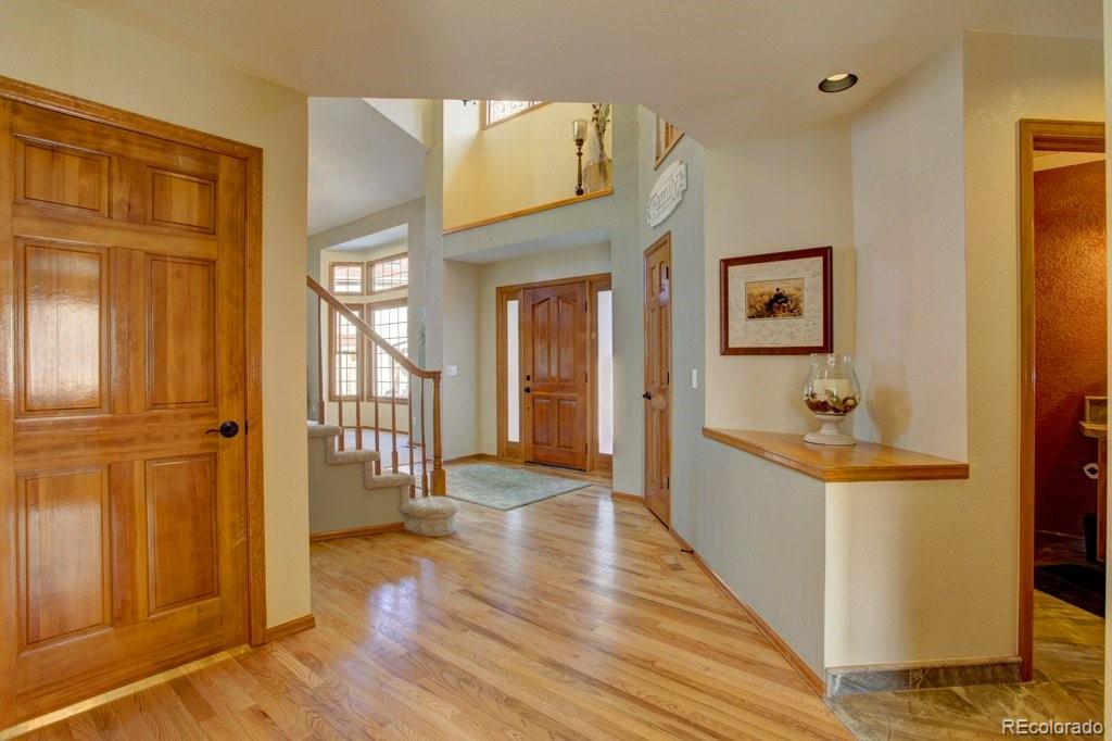 2364 Stratford Court Highlands Ranch, CO 80126 - Photo 3 of 35 a view of a hallway view with wooden floor and staircase