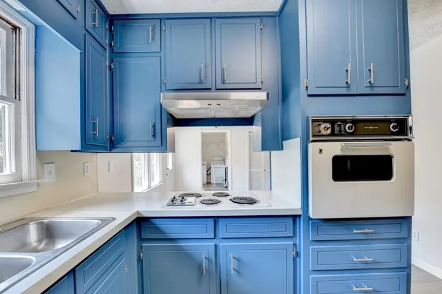 a kitchen with stainless steel appliances granite countertop a sink a stove and cabinets