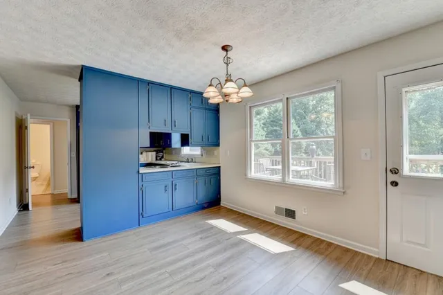 a kitchen with wooden floors and white cabinets