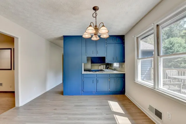 a kitchen with granite countertop wooden cabinets and a stove