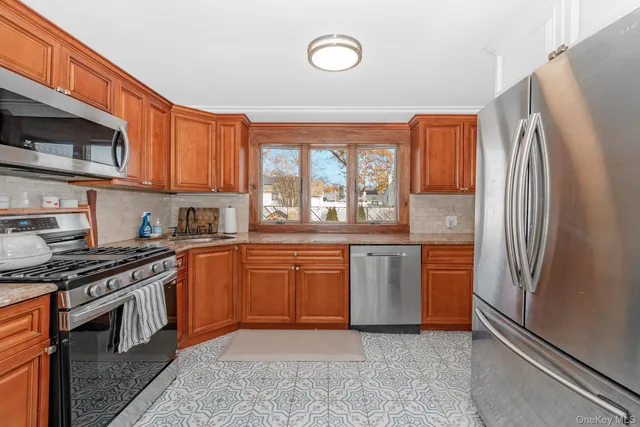 a kitchen with granite countertop stainless steel appliances a stove sink and microwave