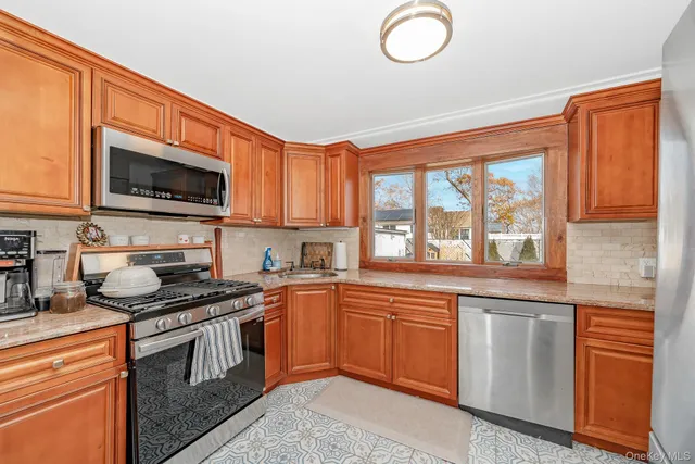 a kitchen with granite countertop a refrigerator stove top oven and sink