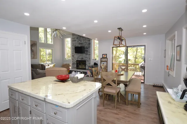 a kitchen with a sink a counter top space and living room view