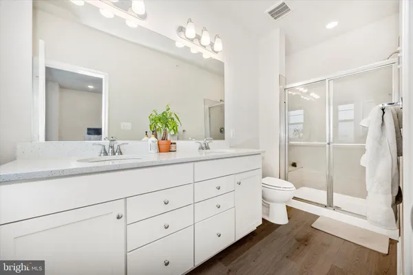 a bathroom with a double vanity sink toilet and shower