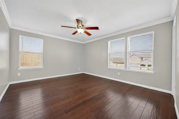 a view of a room with wooden floors and a ceiling fan