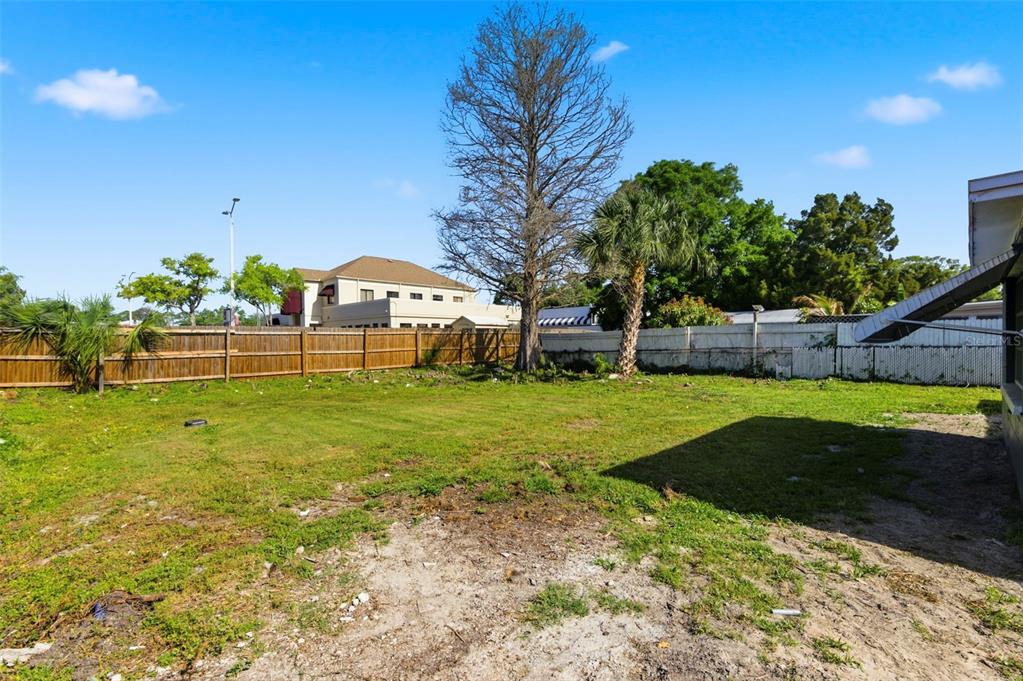 9033 Pegasus Avenue Port Richey, FL 34668 - Photo 43 of 56 a view of a yard with a house in the background