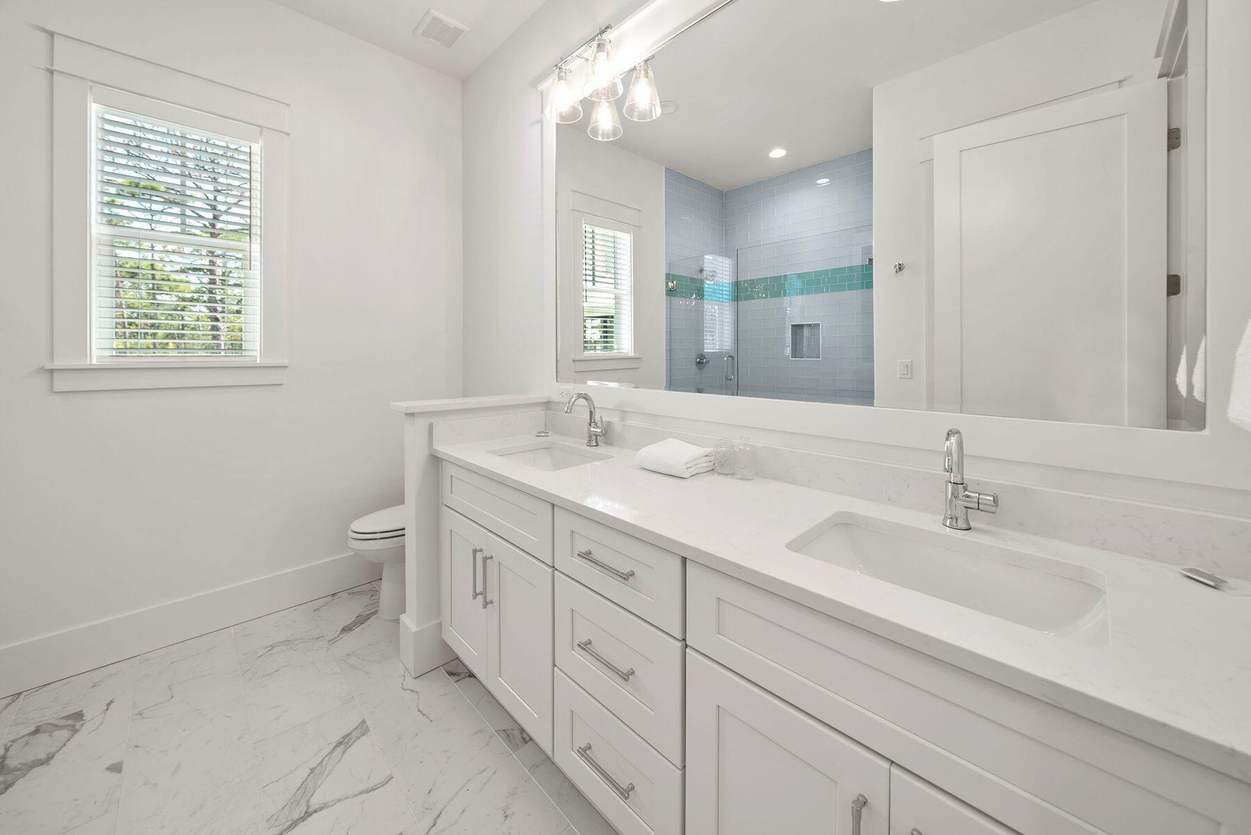 23 Sweet Gum Loop Inlet Beach Inlet Beach, FL 32461 - Photo 20 of 35 a spacious bathroom with a double vanity sink a toilet and a mirror