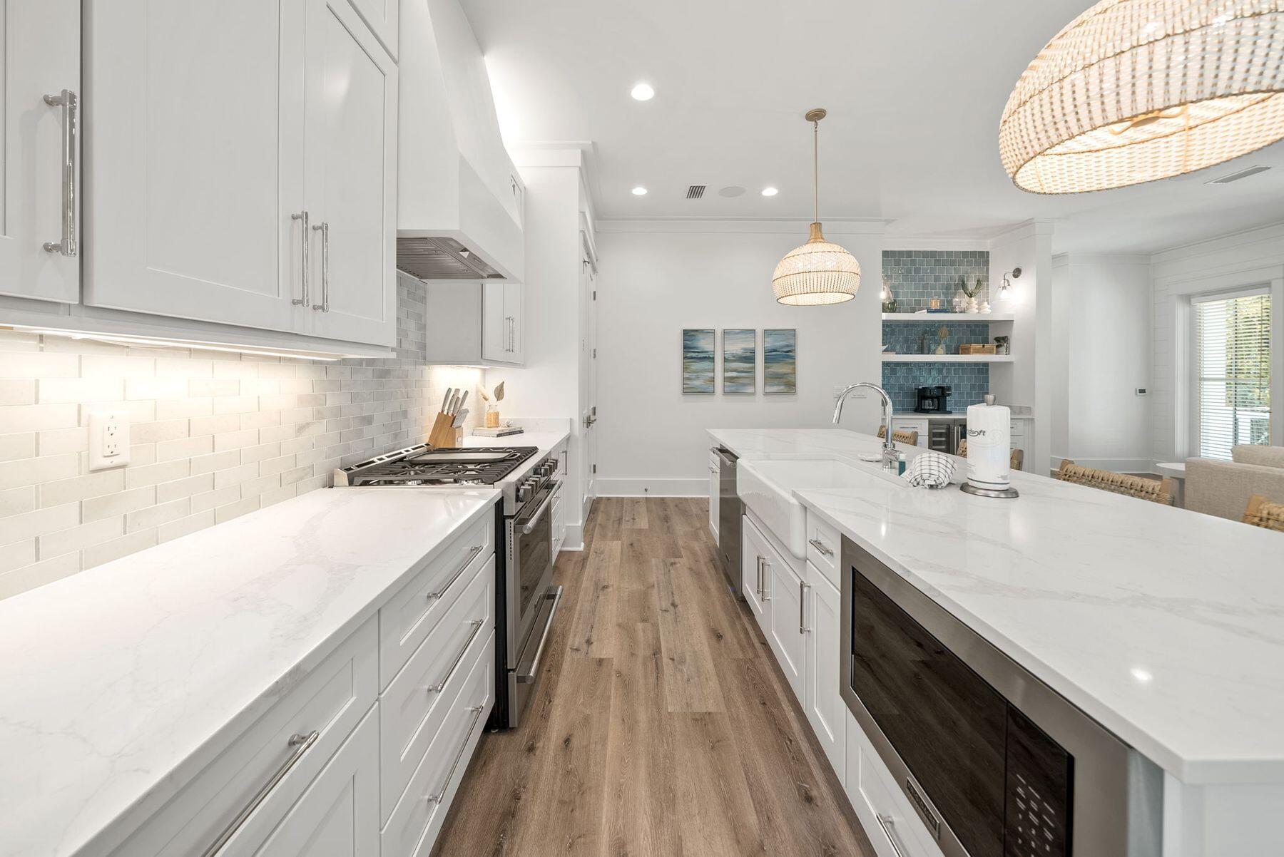 23 Sweet Gum Loop Inlet Beach Inlet Beach, FL 32461 - Photo 7 of 35 a large white kitchen with a large stove a sink dishwasher and white cabinets with wooden floor