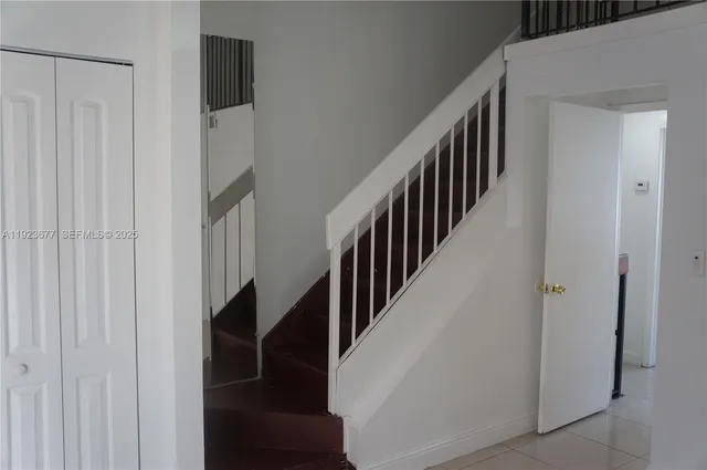a view of staircase with lots of frames on wall and a potted plant