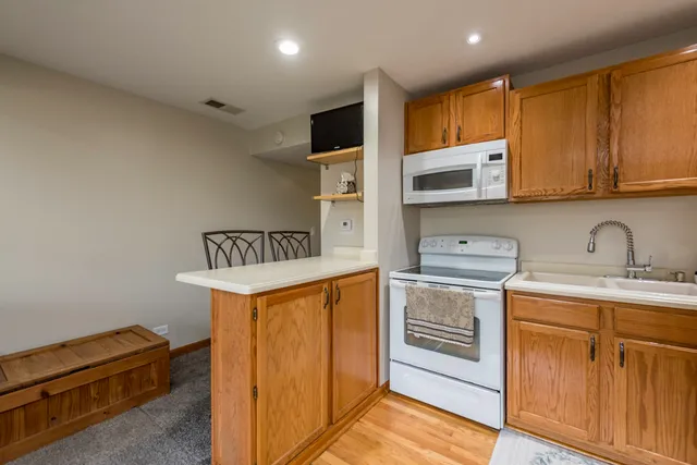 a kitchen with stainless steel appliances granite countertop a stove a sink and a microwave