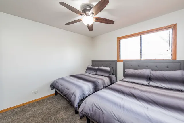 a bedroom with two beds and a large window