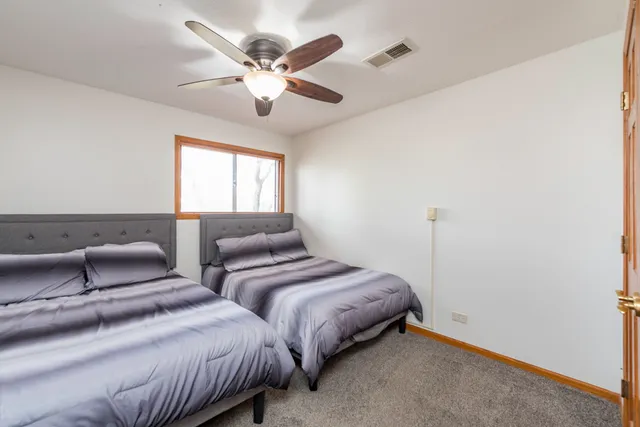 a bedroom with two beds and a chandelier
