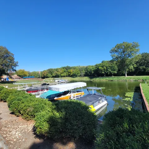 a view of a lake with a yard and large trees