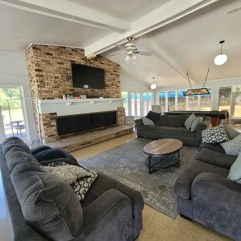 a living room with furniture a flat screen tv and a fireplace