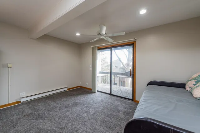 an empty room with windows and ceiling fan