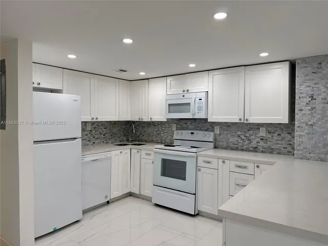 a kitchen with white cabinets stainless steel appliances and sink