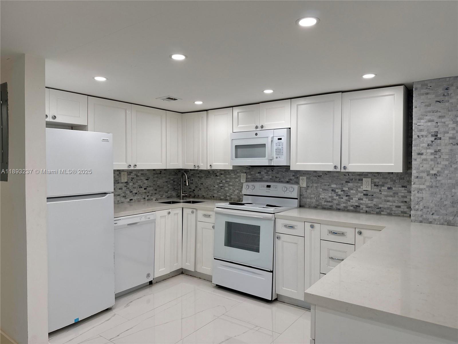 a kitchen with white cabinets stainless steel appliances and sink