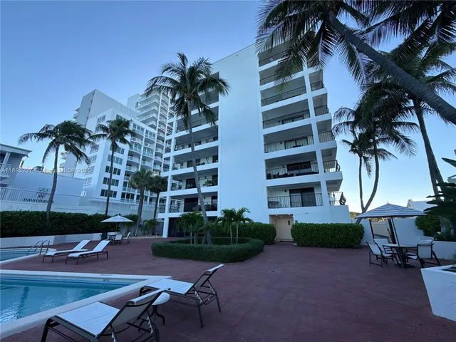 a row of palm trees in front of a house
