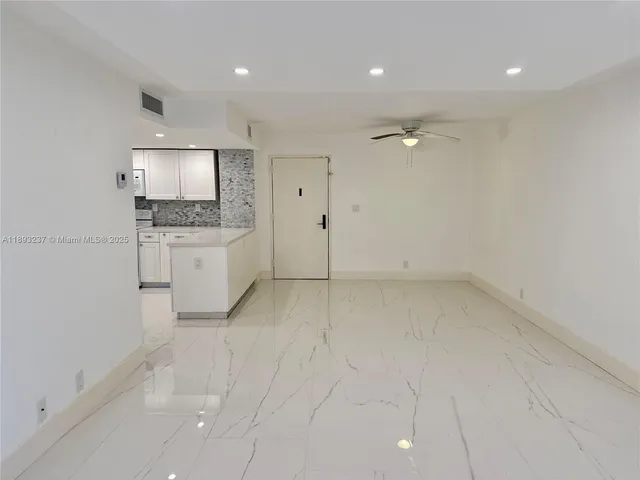 an empty room with kitchen and window