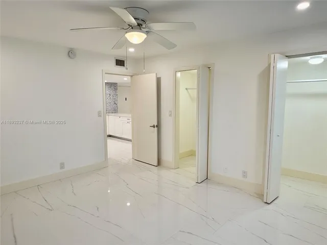 a view of a livingroom with a ceiling fan & entryway