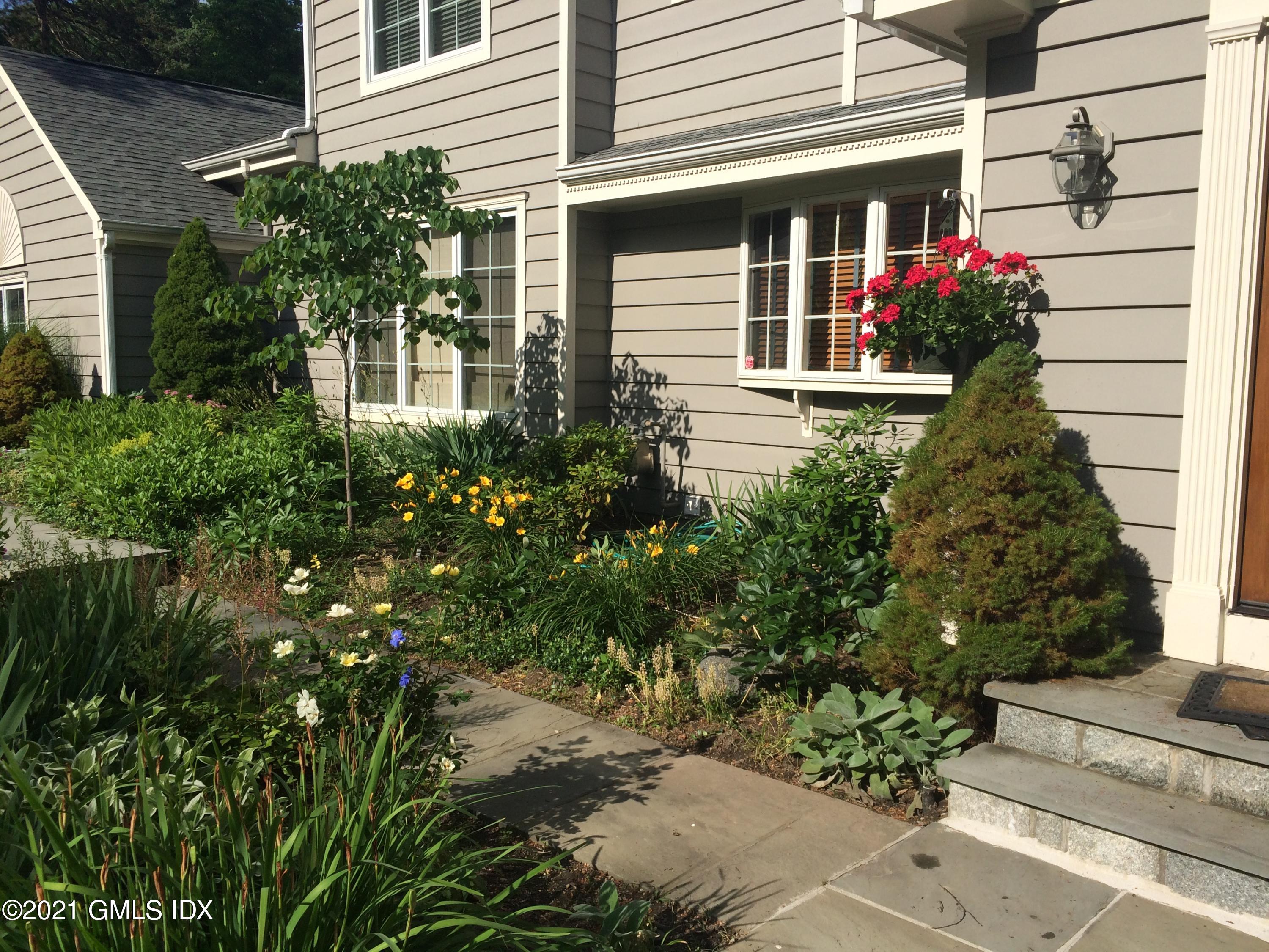 3 Old Wagon Road Old Greenwich, CT 06870 - Photo 22 of 37 a front view of a house with a garden