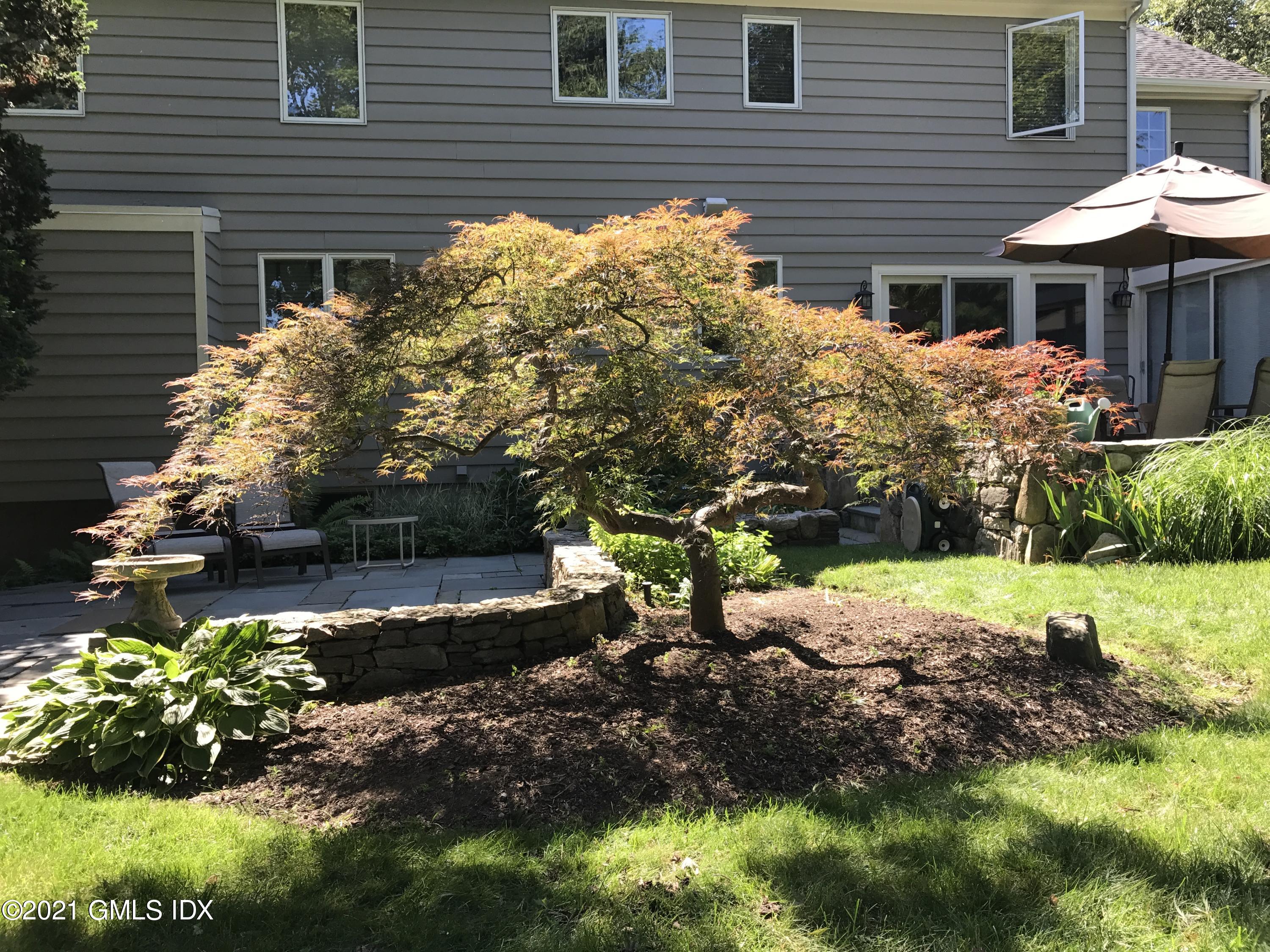 3 Old Wagon Road Old Greenwich, CT 06870 - Photo 27 of 37 a front view of a house with a yard and a garden