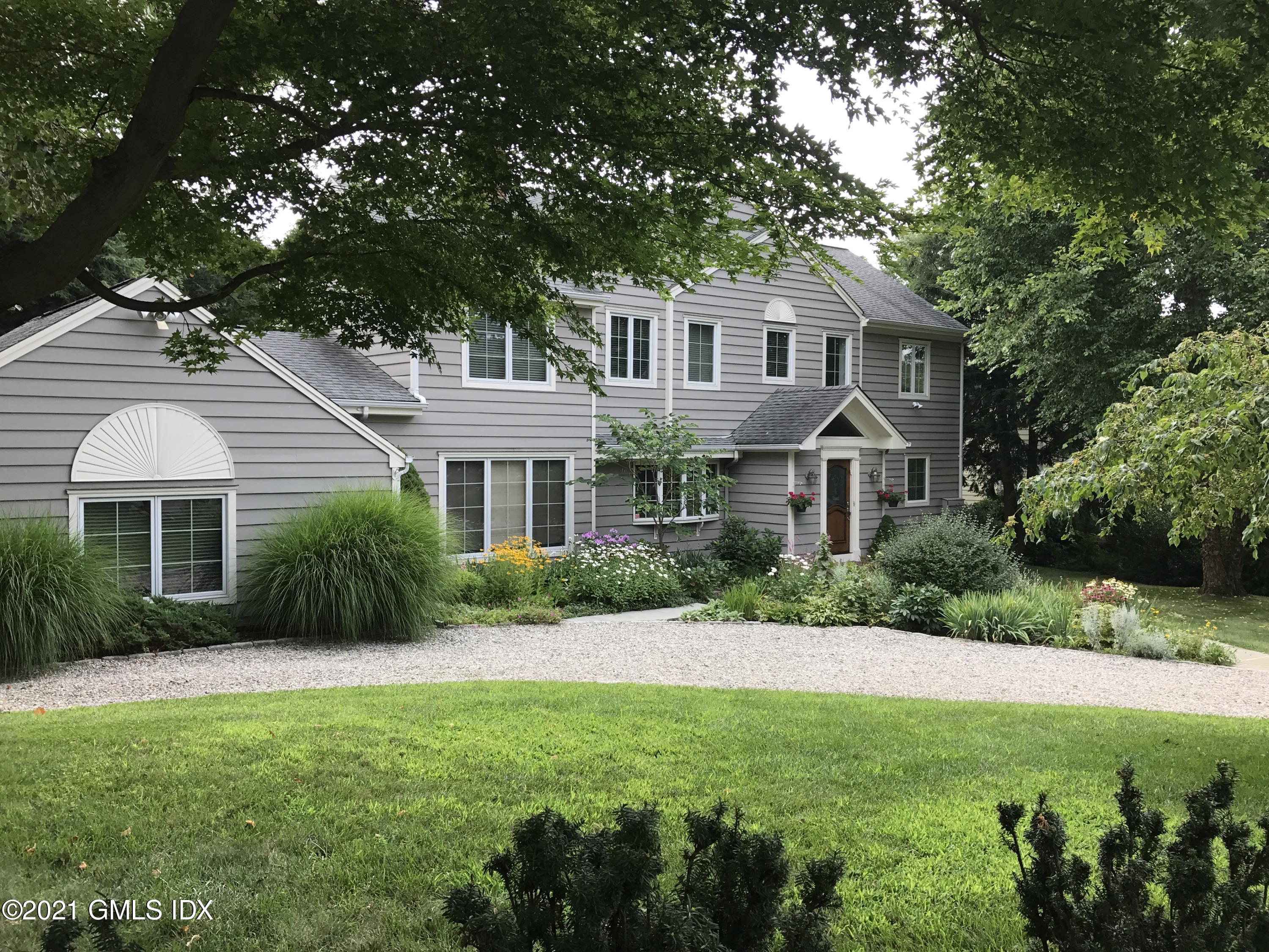 3 Old Wagon Road Old Greenwich, CT 06870 - Photo 31 of 37 a front view of a house with a yard and potted plants