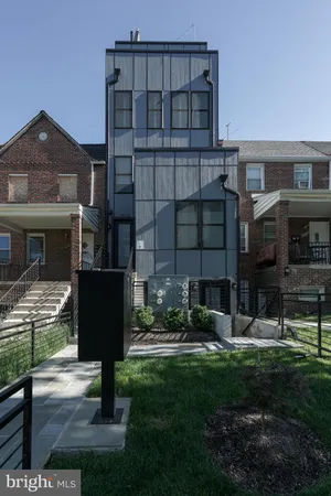 a front view of a residential apartment building with a yard