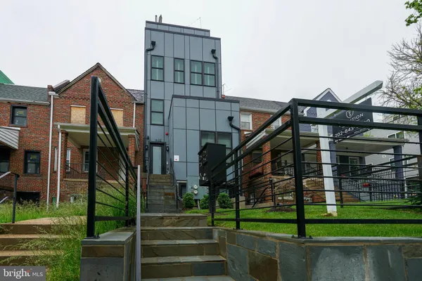 a front view of a residential apartment building with a yard