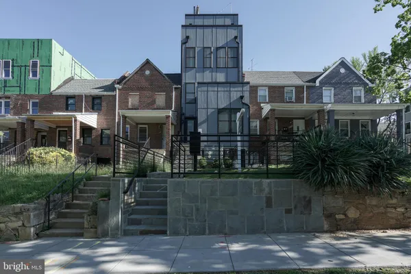 a kitchen with stainless steel appliances kitchen island granite countertop a table chairs in it and white cabinets